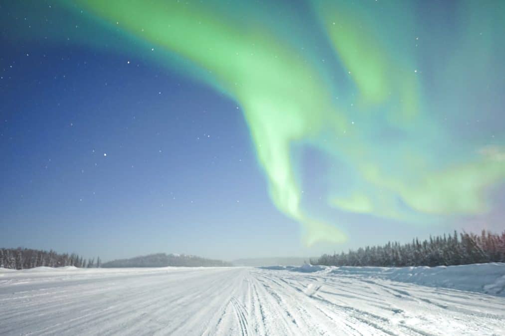 northern lights dancing above the ice road in yellowknife canada
