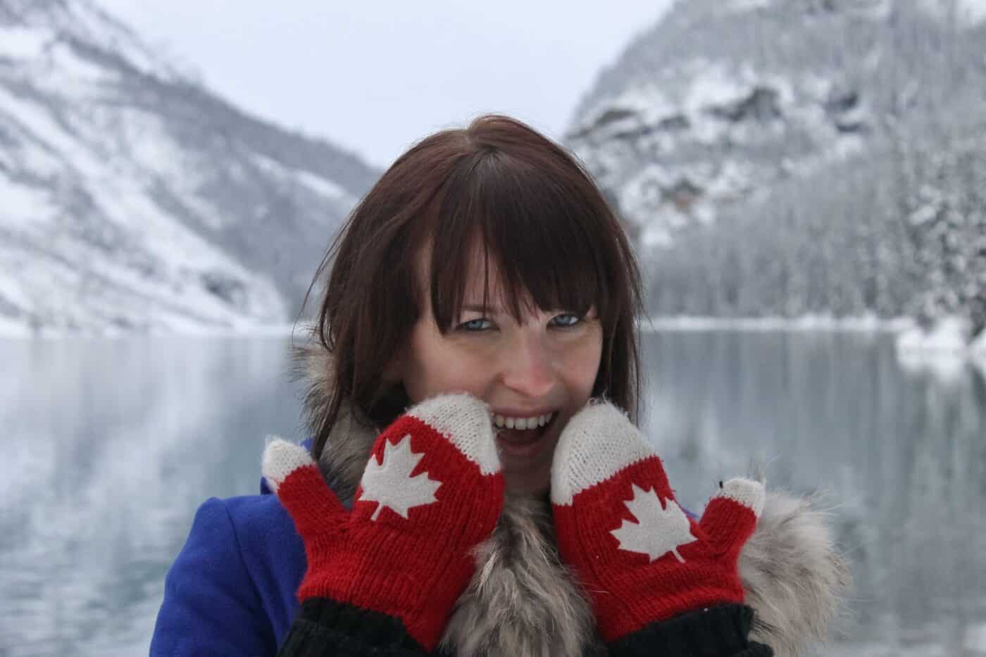 girl wearing mitts in front of lake louise canada