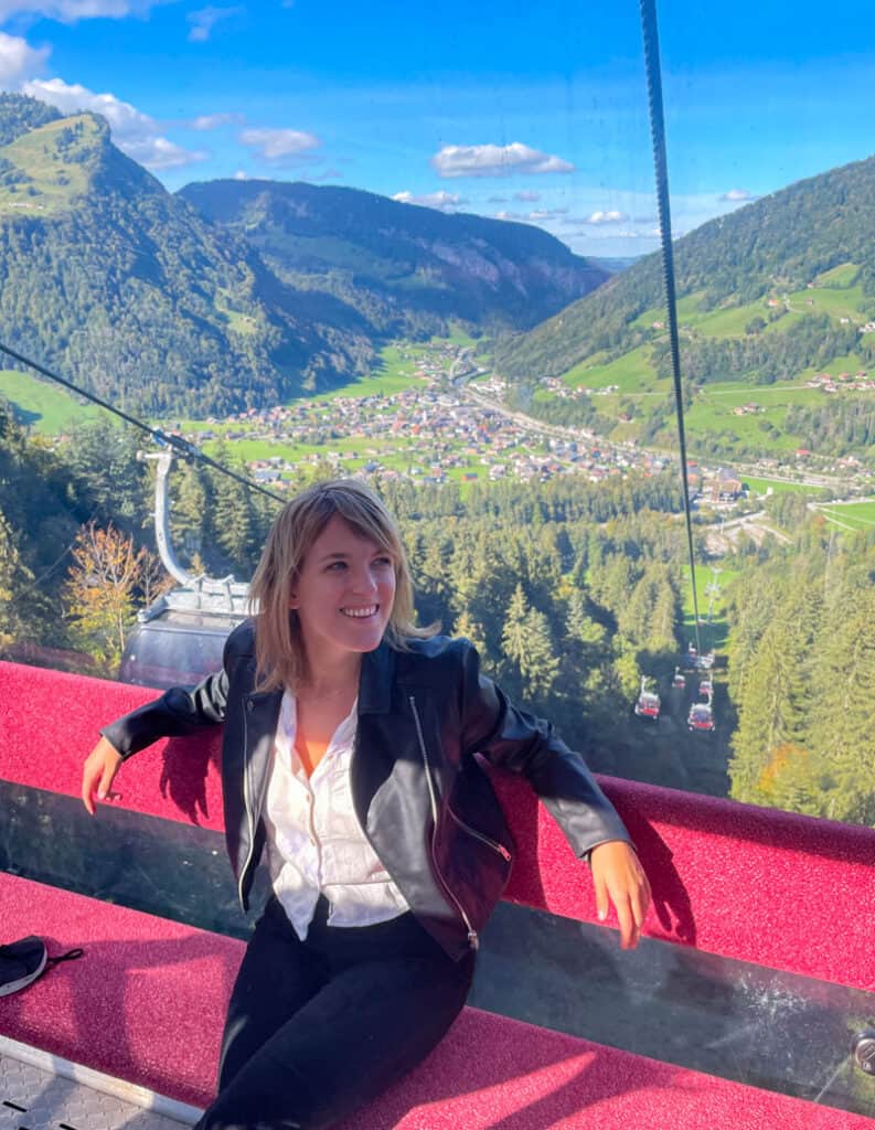 girl riding mellau cable car with mountains in the background
