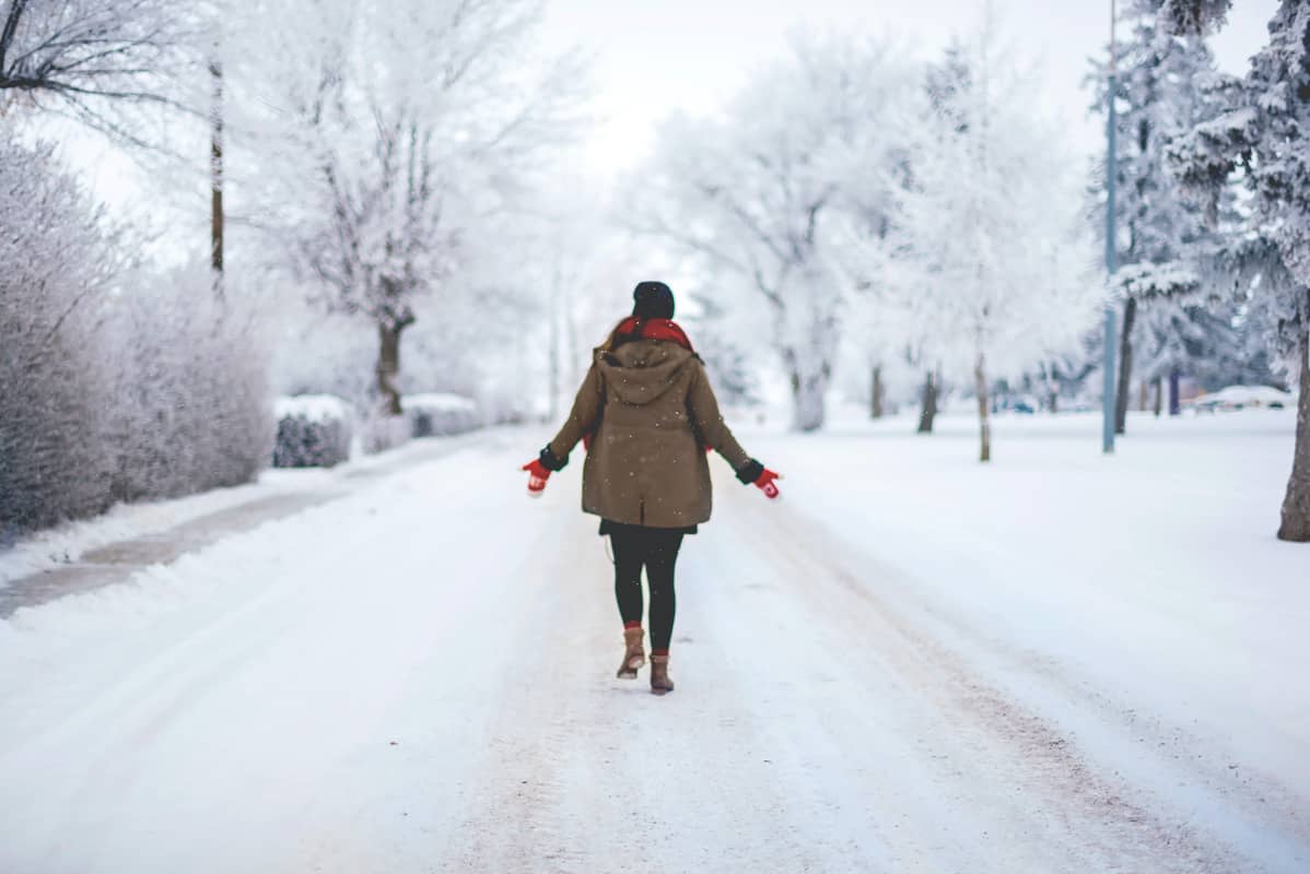 women walking in snow wearing winter jacket