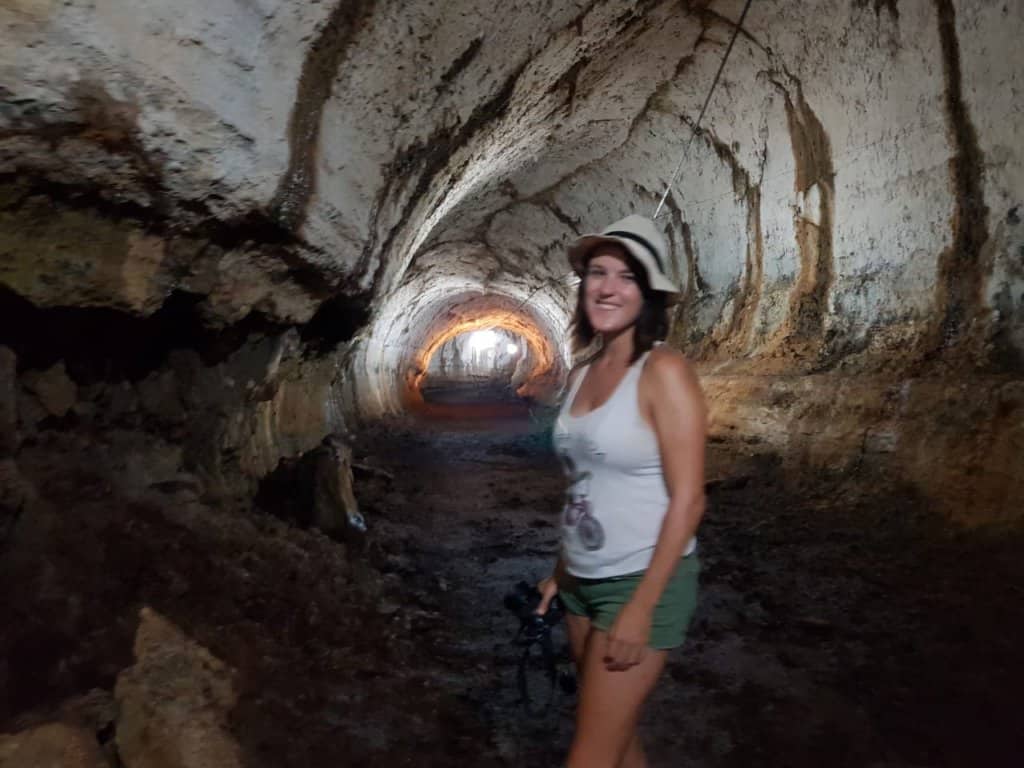 Lora walking through lava tunnels, exploring the fascinating geological formations of the Galapagos Islands' volcanic landscapes.