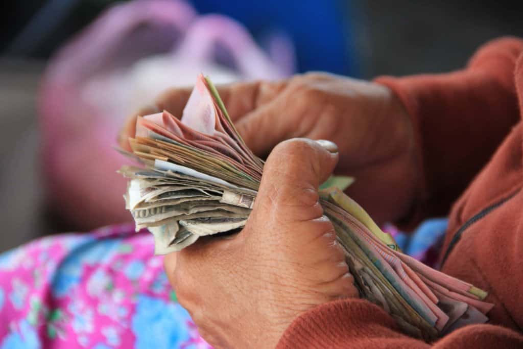 women's hand counting different currencies