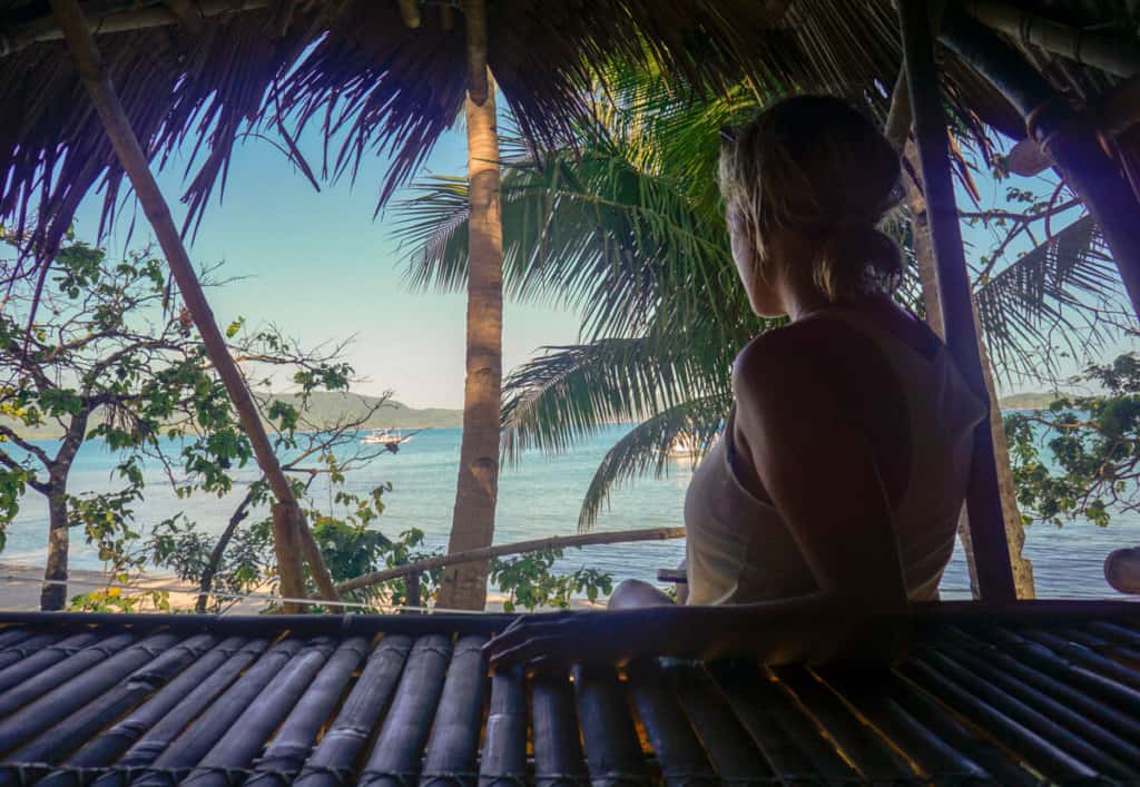 lora looking out at ocean and palm trees in palawan