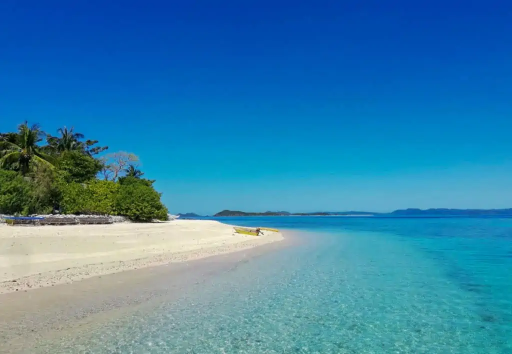 turquoise water by white sand beach in palawan