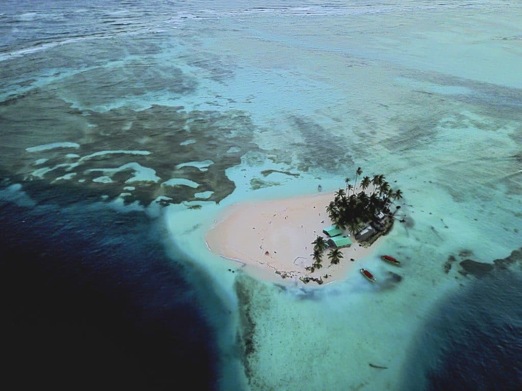 aerial shot of San Blas Islands in Panama. sand bar surrounded by turquoise water and reefs.
