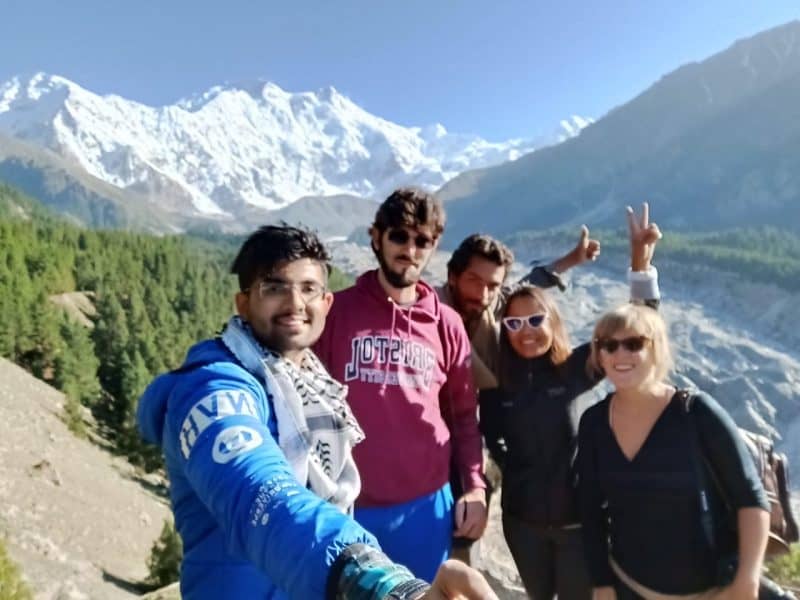 man taking a selfie of friends in front of mountain in pakistan