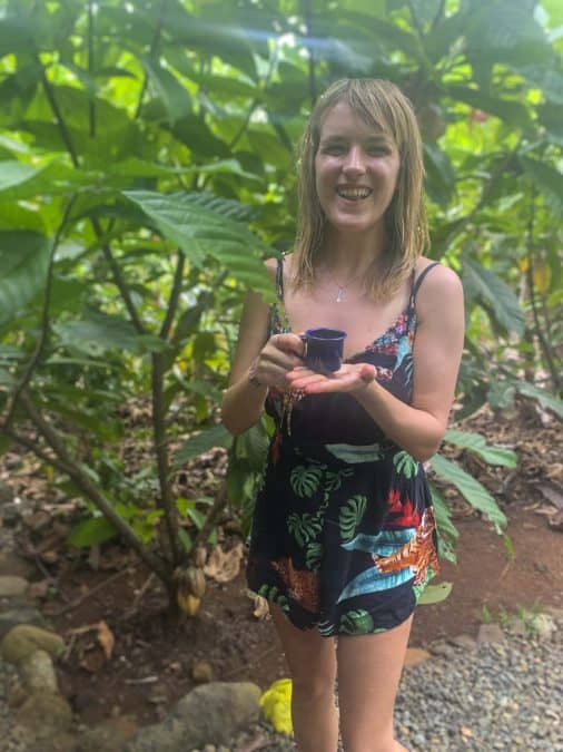 lora drinking Costa Rican coffee next to a Cacao Plant