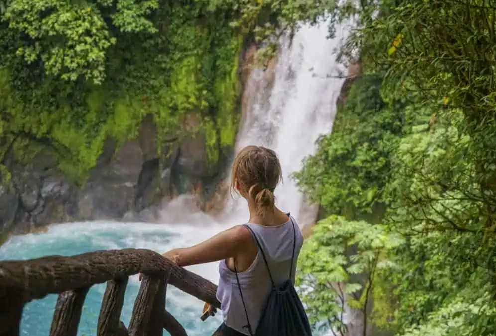 Lora hiking in Costa Rica, enjoying the view of a breathtaking blue waterfall at rio celeste