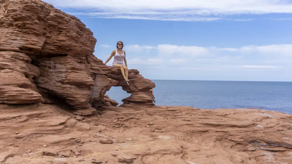 girl sitting on red clilffs cavendish pei