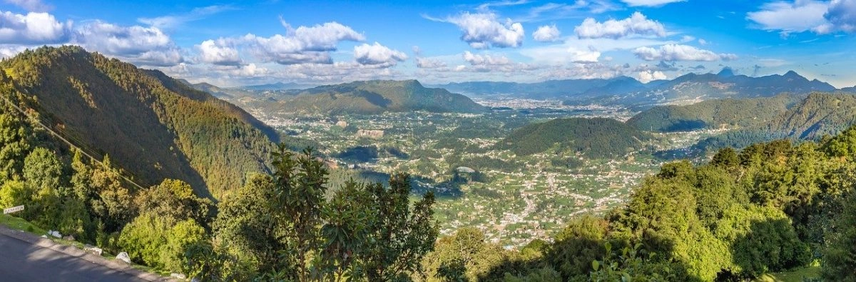 a stunning landscapes of mountains and lakes in guatemala with a blue sky and clouds above the mountains