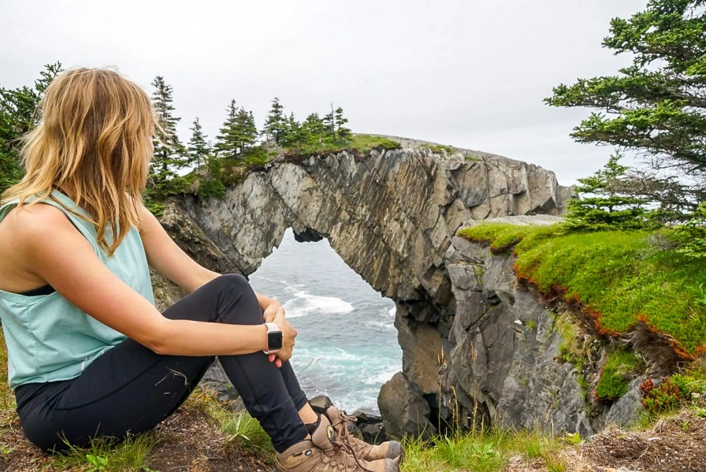 girl looking over berry head sea arch