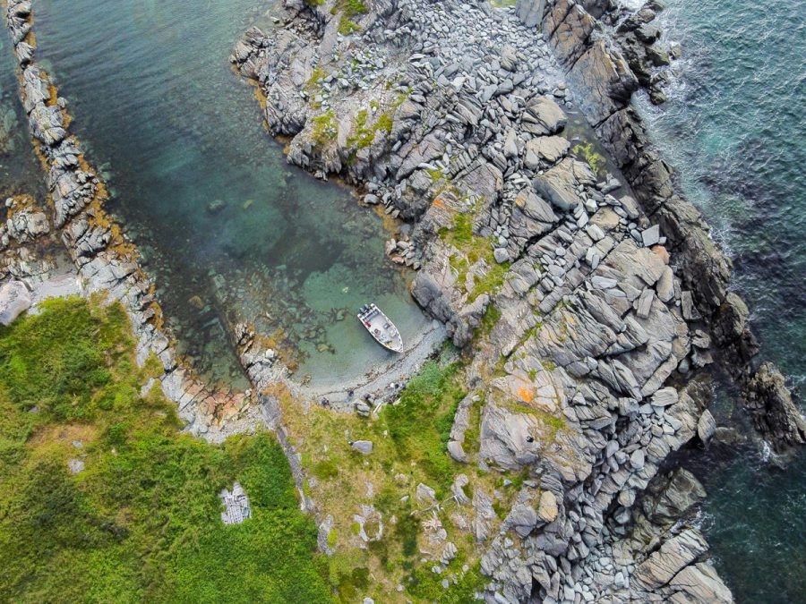 aerial photo of bragg's island in newfoundland. boat is parked in a small cove.