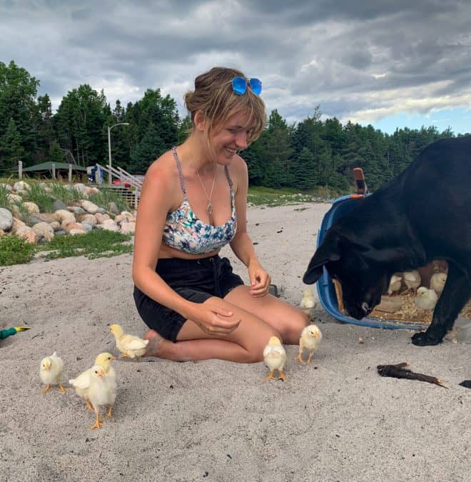 lora playing with chicks and dog at beach