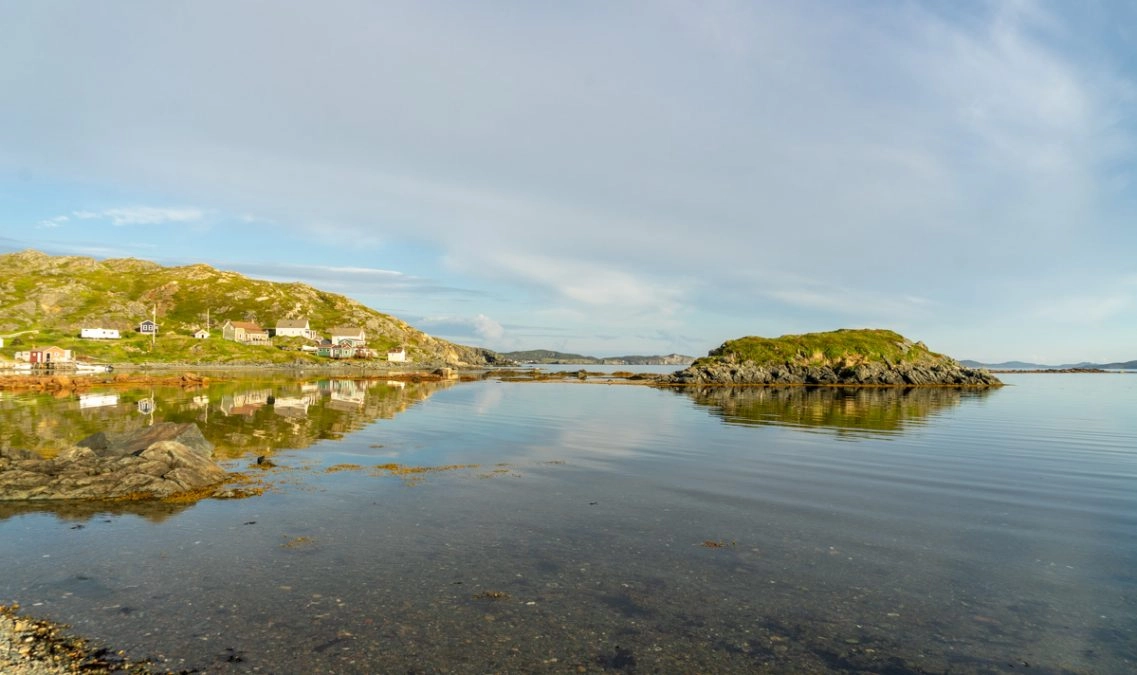 the town of twillingate reflecting in the ocean at sunset