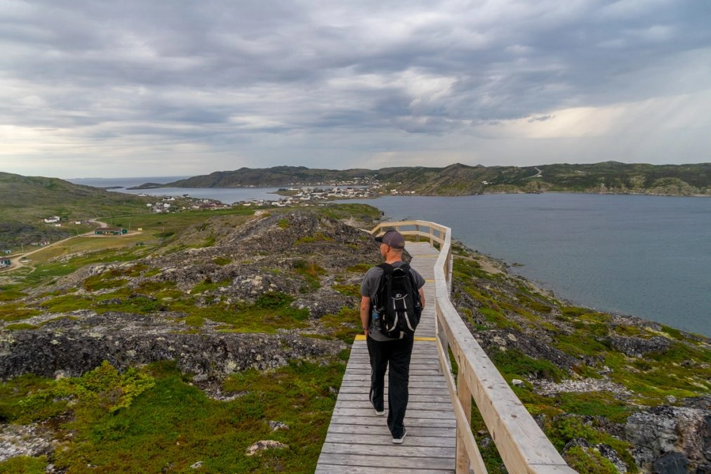 man hiking in fogo island along a coastal trail