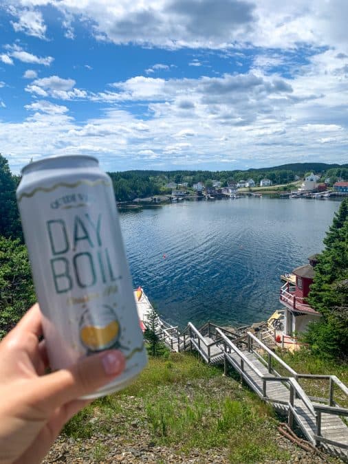 holding a can of day boil beer looking over a lake in newfoundland