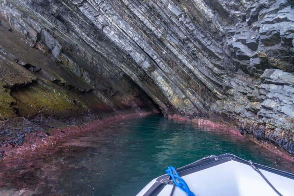a boat going into a sea cave in newfoundland