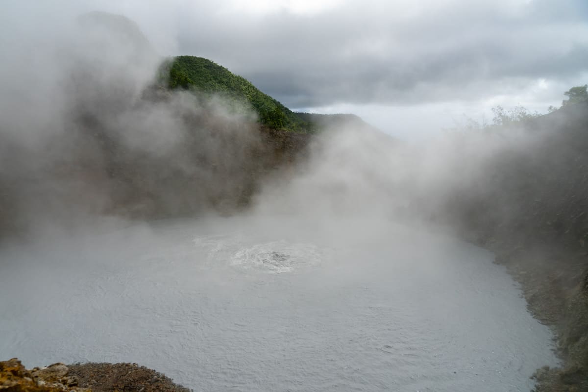 boiling lake in dominica. steam is coming from the lake.
