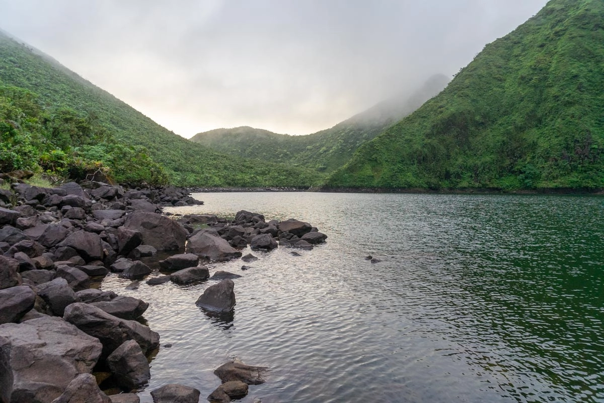 view of boeri lake with lush green mountains behind it