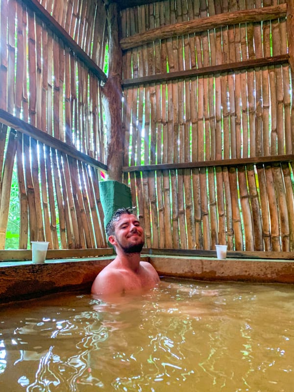 man soaking in hot spring at tias hot spa dominica