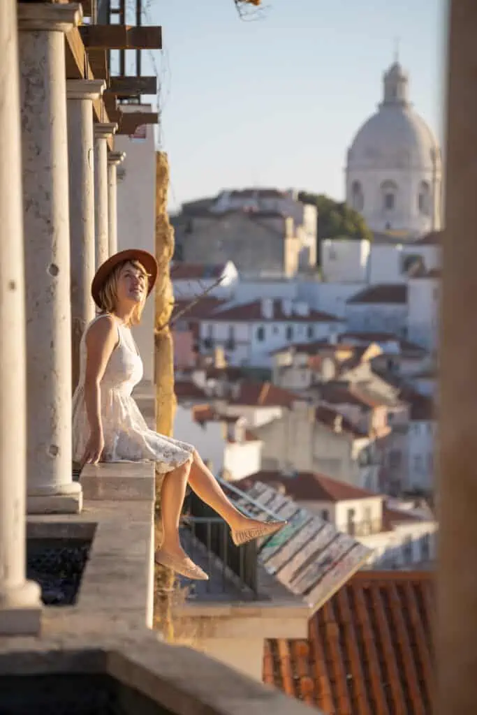 girl sitting on ledge in lisbon portugal