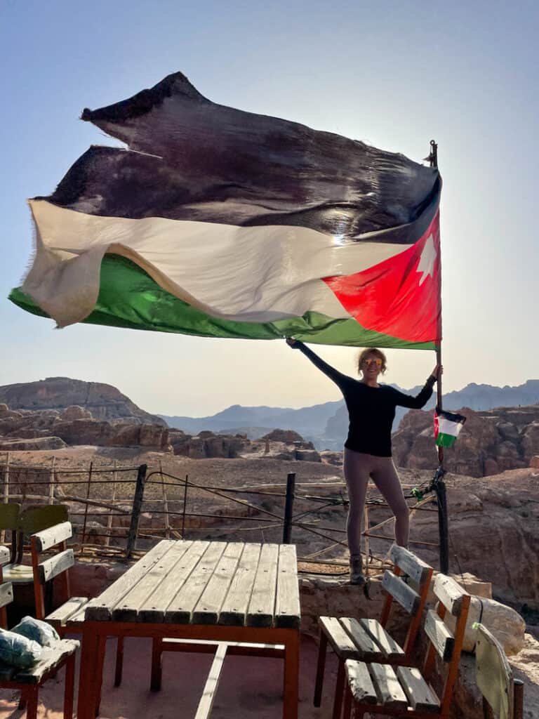 girl hiking with Jordan flag on traverse journeys tour