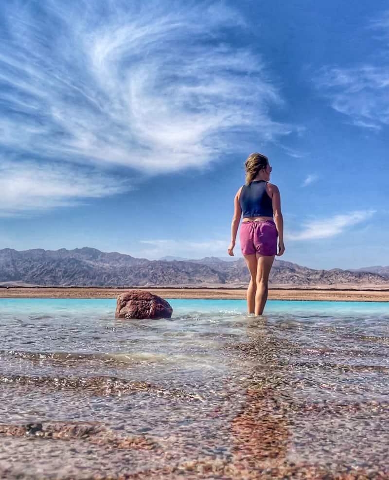 girl walking in turquoise water dahab egypt