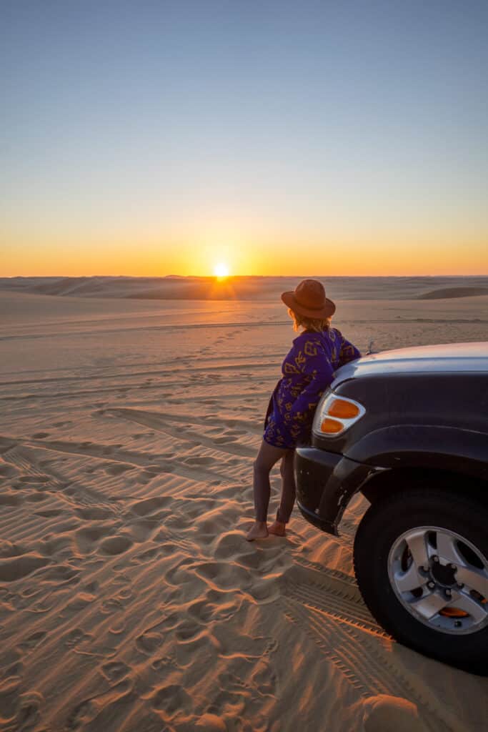 girl in desert looking over sunset