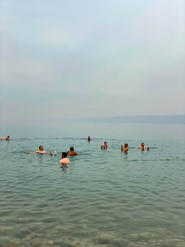 people swimming in the dead sea in jordan