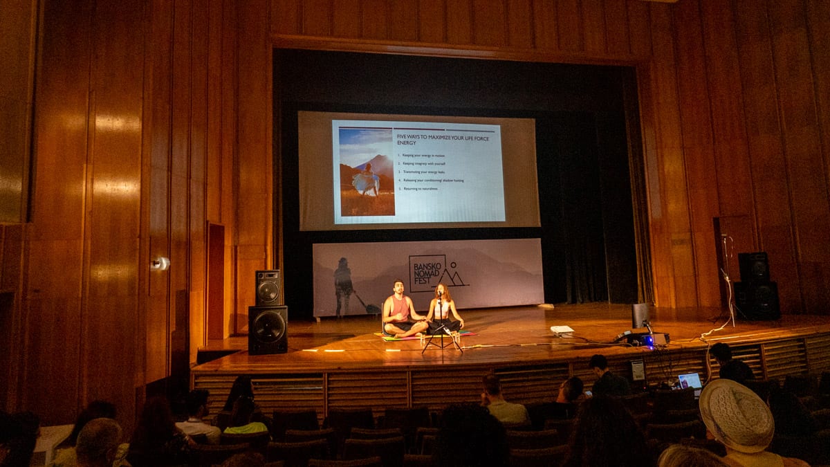 A group of people on stage in a large auditorium during the Bansko Digital Nomad gathering.