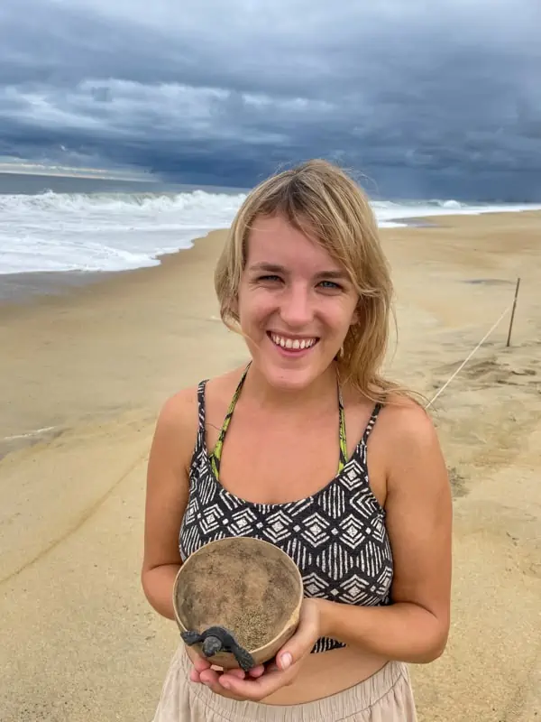 lora holding a baby sea turtle