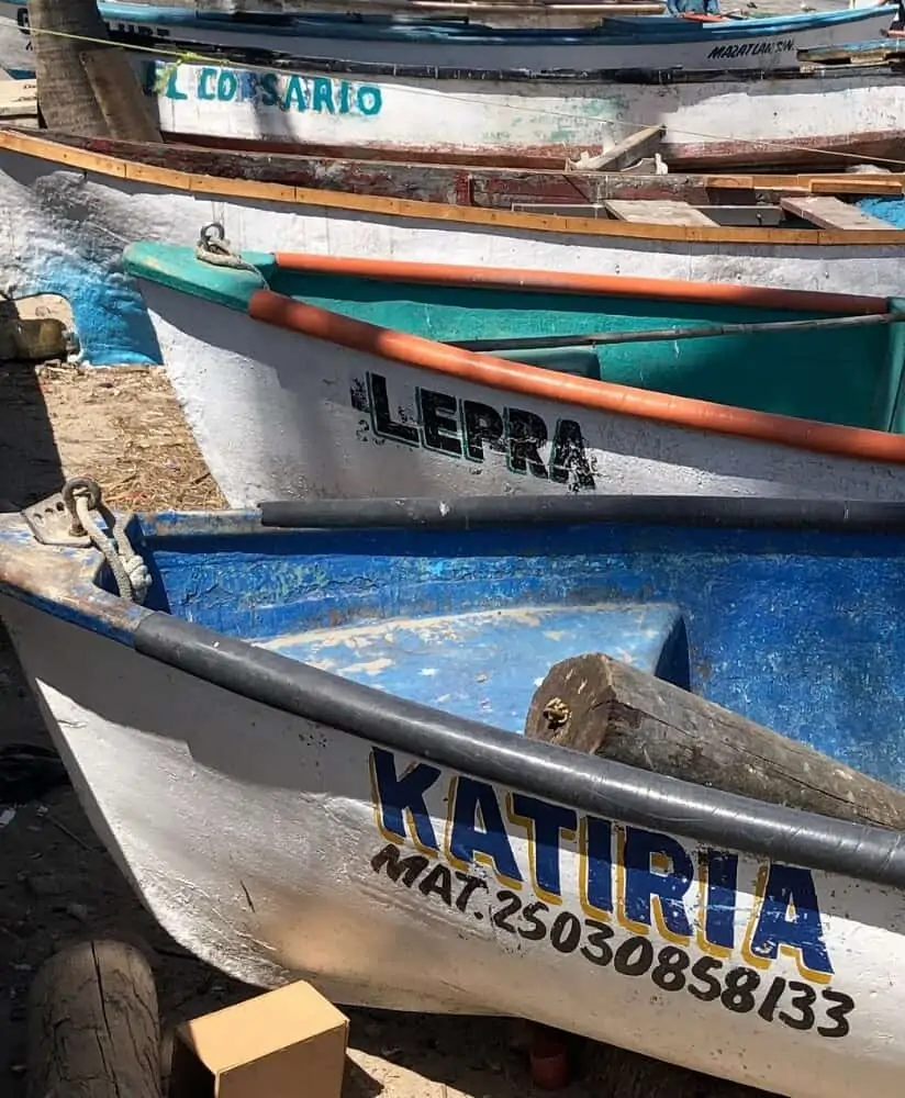 Colorful boats resting on the sandy beach in Mazatlán, Mexico, creating a picturesque scene.