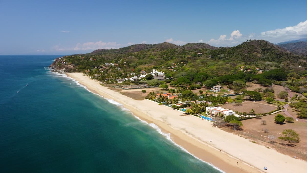 aerial view of the beautiful beach in Sayulita, Mexico, with turquoise water and people enjoying the sun.