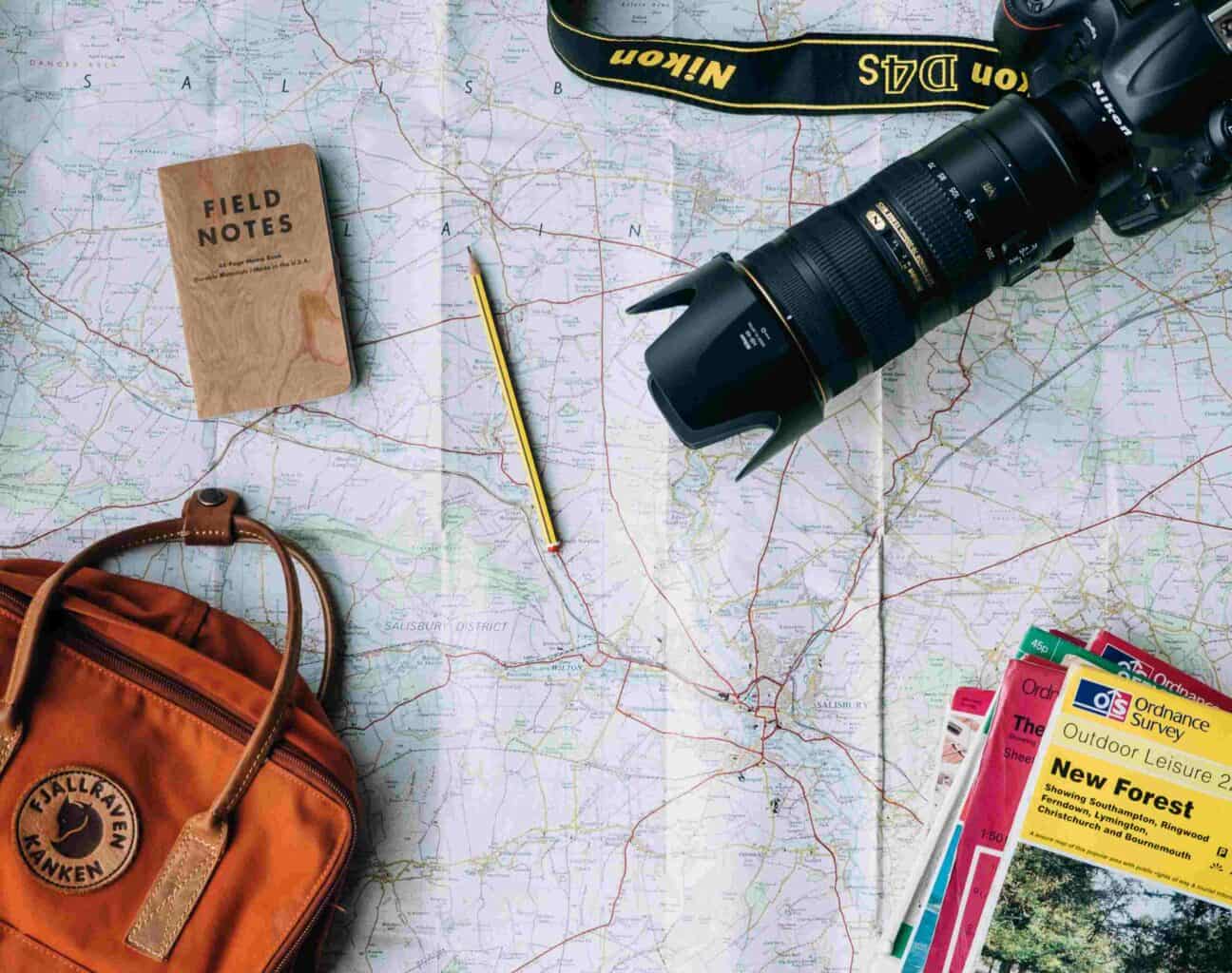 camera and notebook on travel map