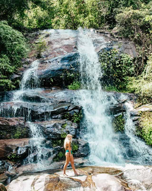 girl standing by waterfalls in chiang mai