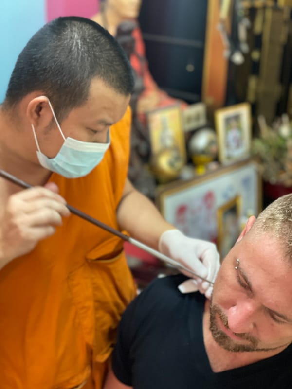 ajarn rung tattooing a man in chiang mai thailand