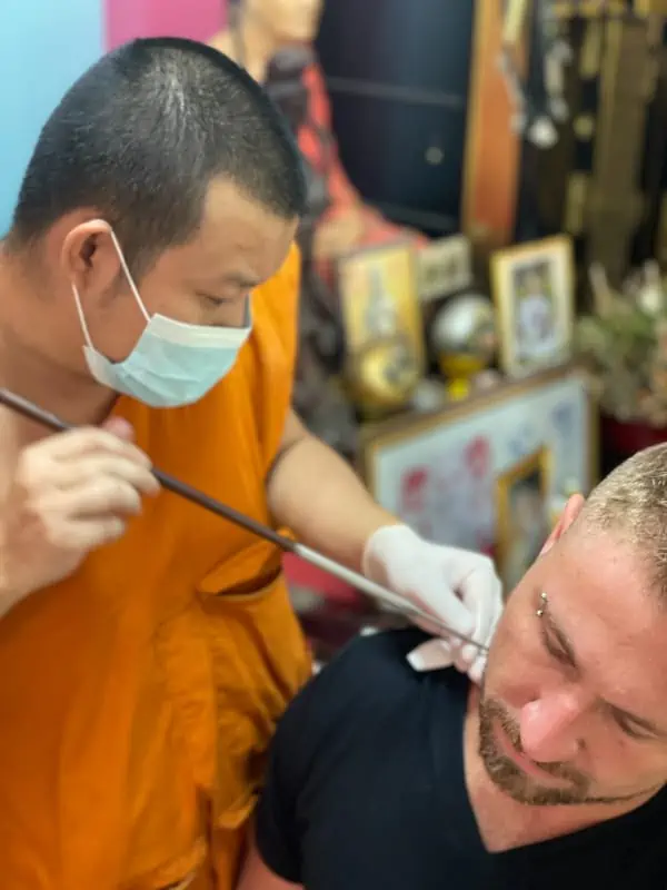 ajarn rung tattooing a man in chiang mai thailand