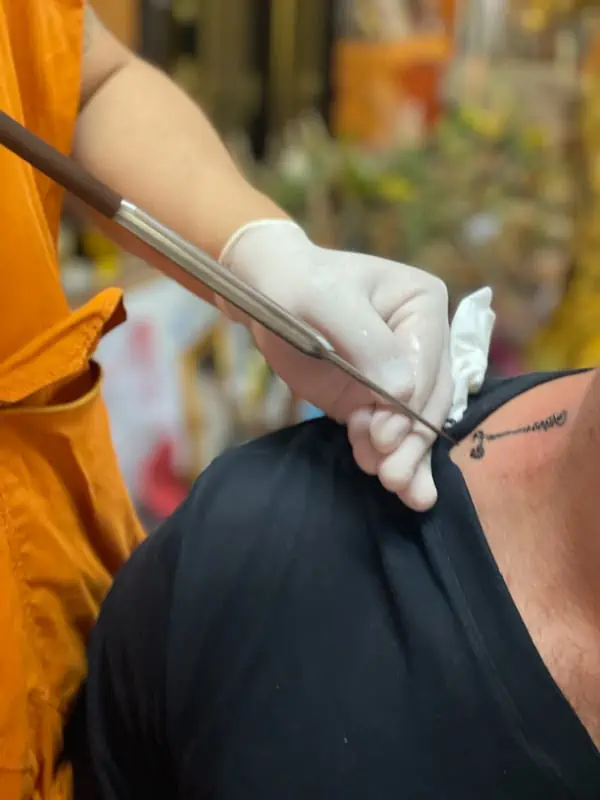 man getting a sak yant tattoo