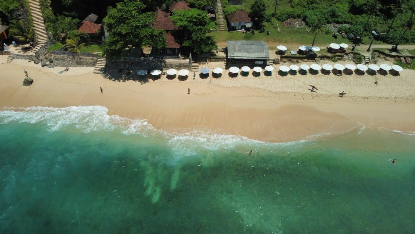 drone shot of white sand beach in uluwatu