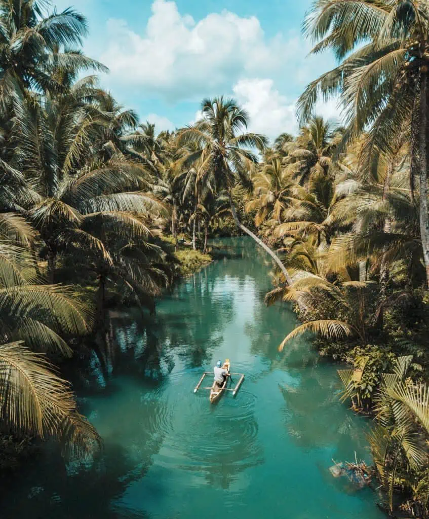 man on boat on turquoise water in siargao island