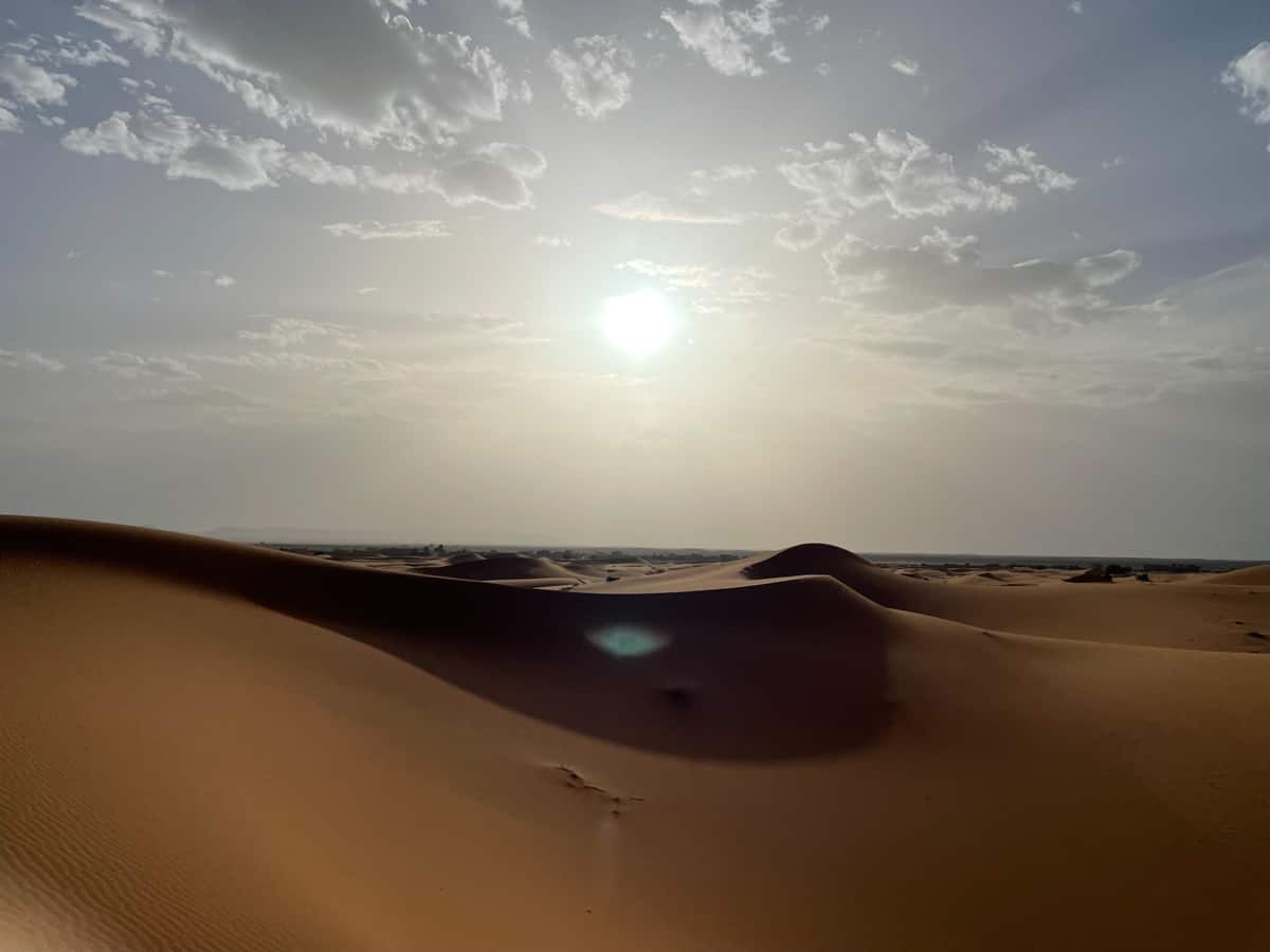 vast desert in morocco. the sun is setting over it.