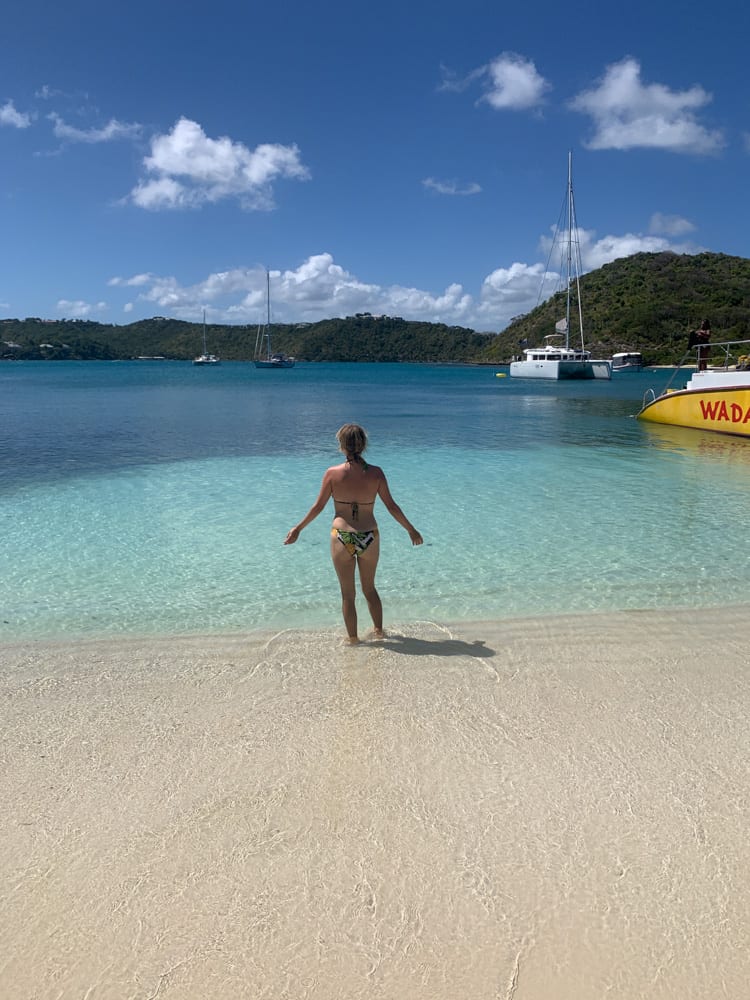 lora looking out at turquoise water in antigua with clouds in background
