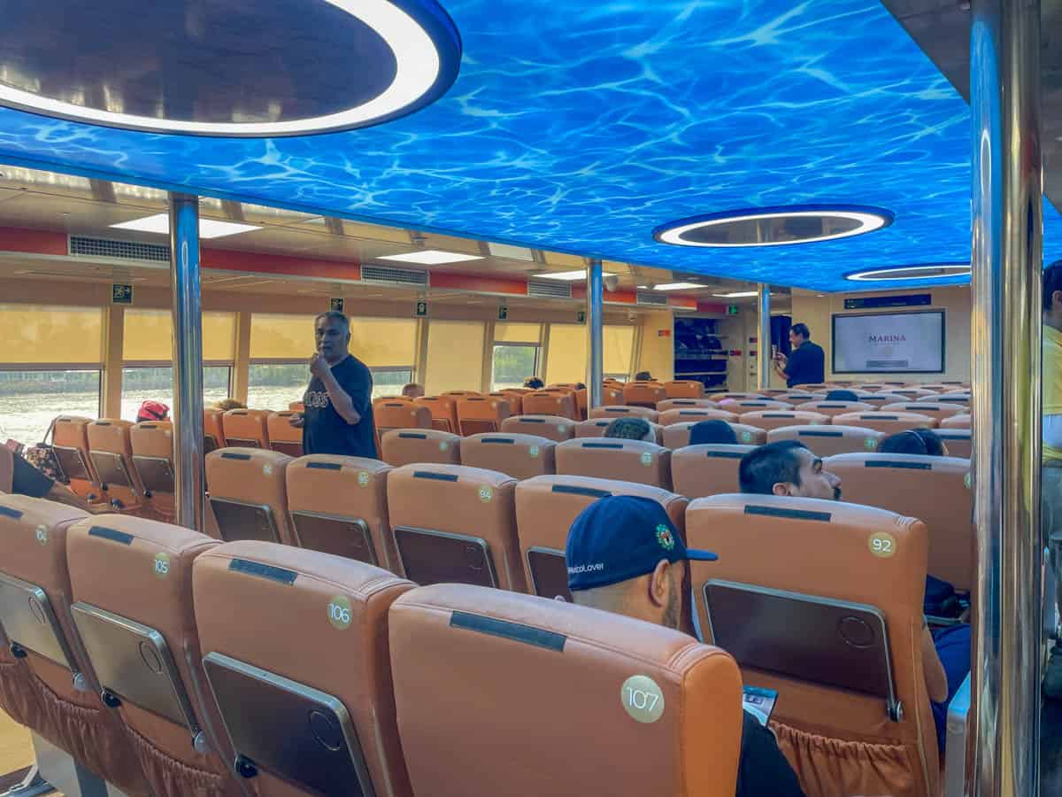 The inside of a boat with people sitting on the seats.