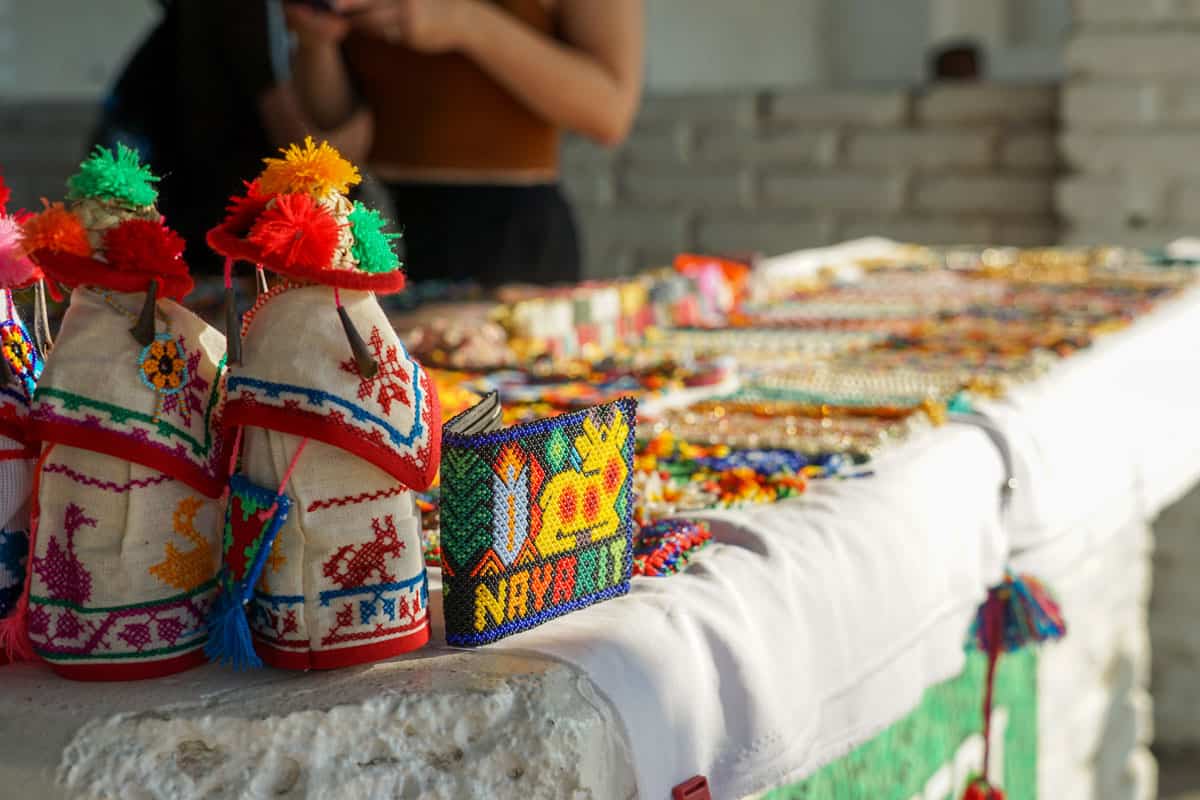 A table with a lot of colorful handcraft items on it.