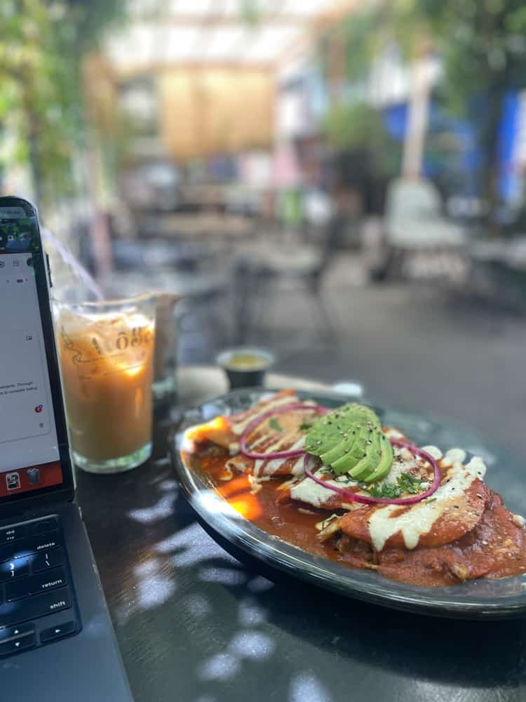 A laptop on a table with a plate of food in one of the best places in Mexico for digital nomads.