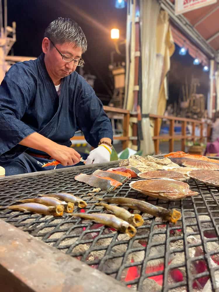 japanese man grilling fresh seafood