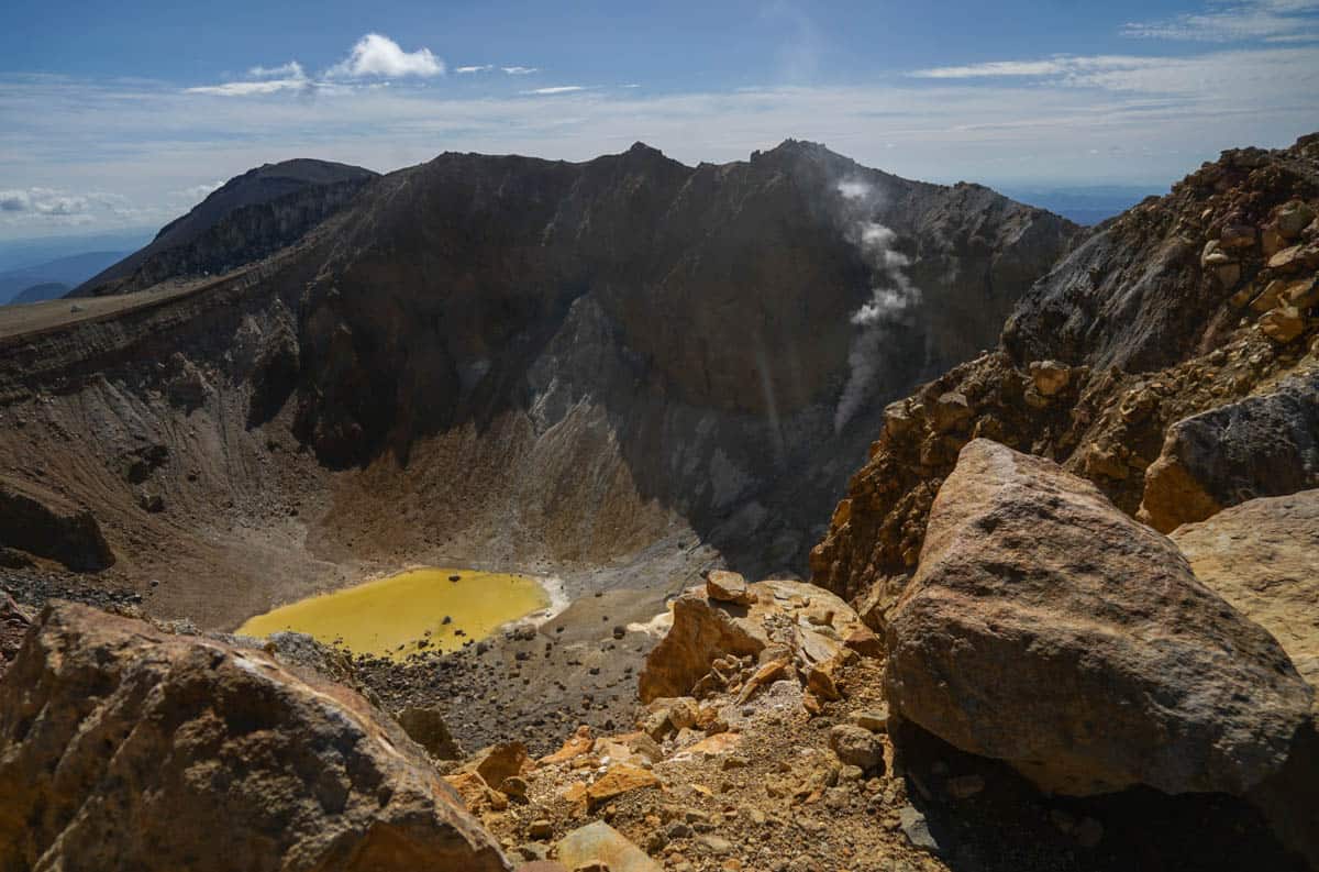 A crater with a yellow lake in the middle.