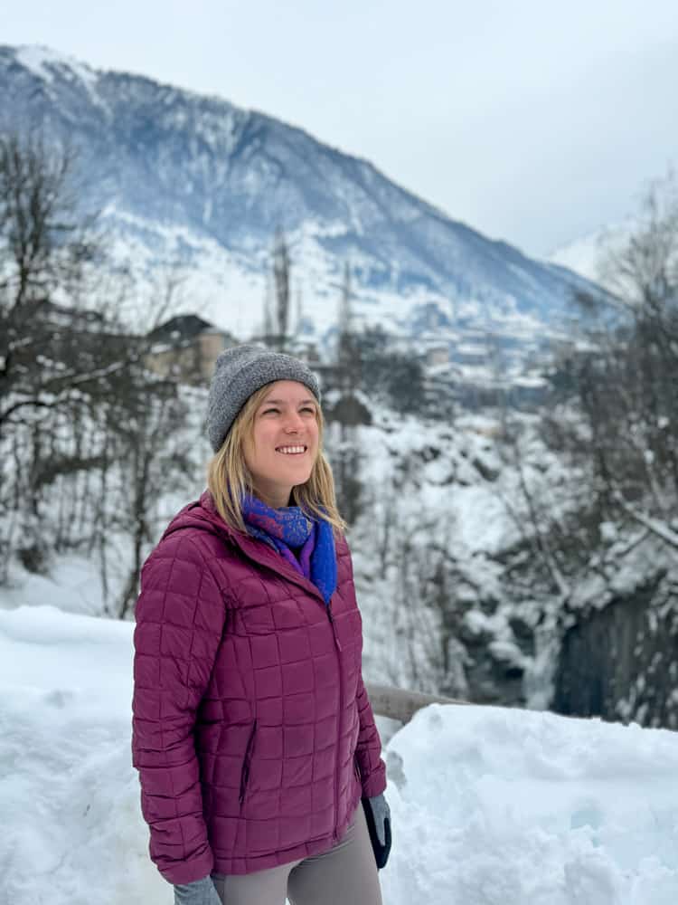 A woman in a purple coat in the snow.