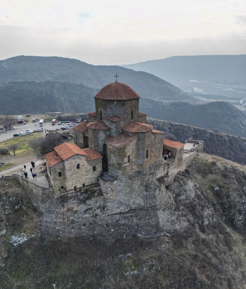 An aerial view of a church on top of a mountain.