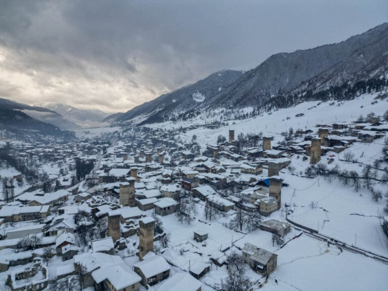 A snowy town with buildings and mountains.